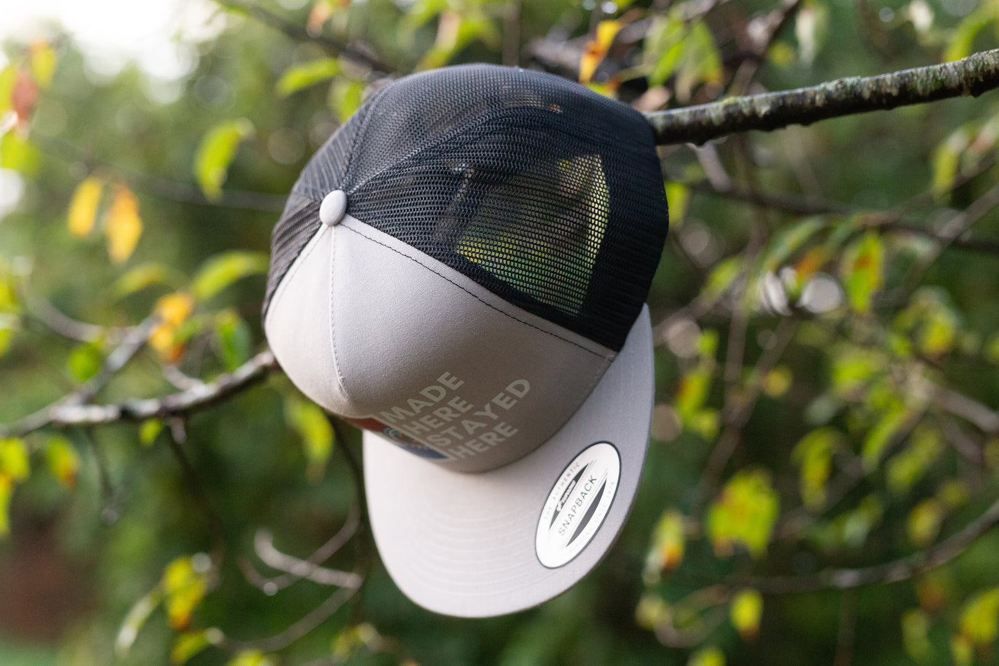 "MADE HERE, STAYED HERE" FLATBILL SNAPBACK TRUCKER HAT